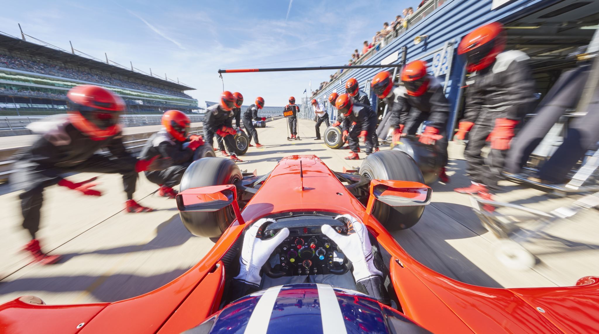 Pit-crew-ready-for-formula-one-race-with-car-in-pit-stop